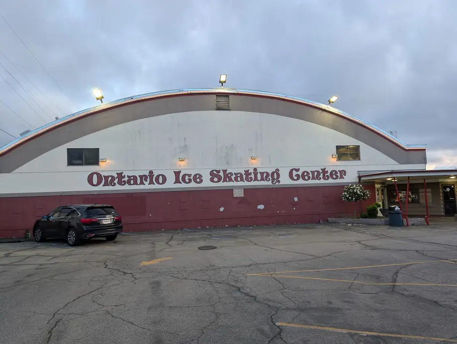 The arched Ontario Ice Skating Center building on Holt Blvd at dusk with its painted lettering